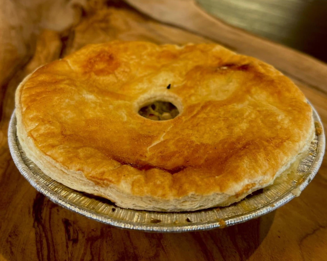 Chicken pieces with Sautéed leeks in a herb white wine sauce, topped with a flaky puff pastry lid.