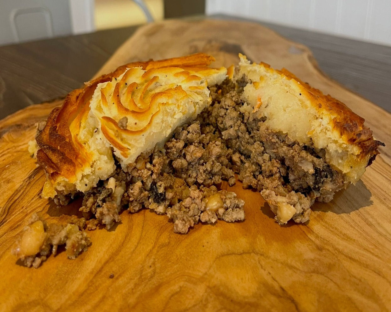 Traditional Shepherds pie made with ground lamb,beans,mushrooms,carrots,onions & tomatoes topped with truffle oil infused mash. cut in half