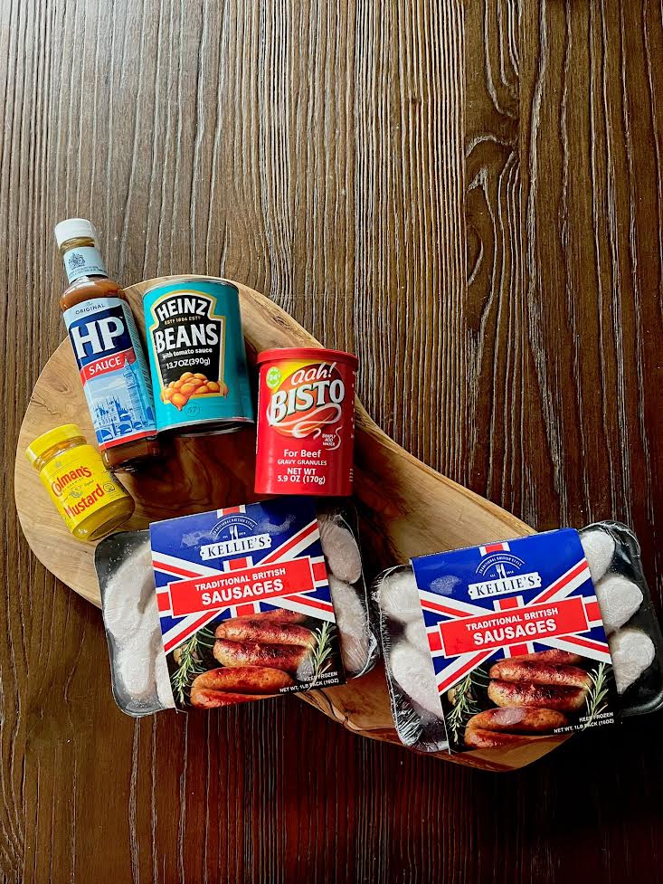 A selection of British Food essentials including; packs of traditional British Sausages, Bisto Gravy Granules, Colman's English Mustard, HP Brown Sauce and Heinz Baked Beans